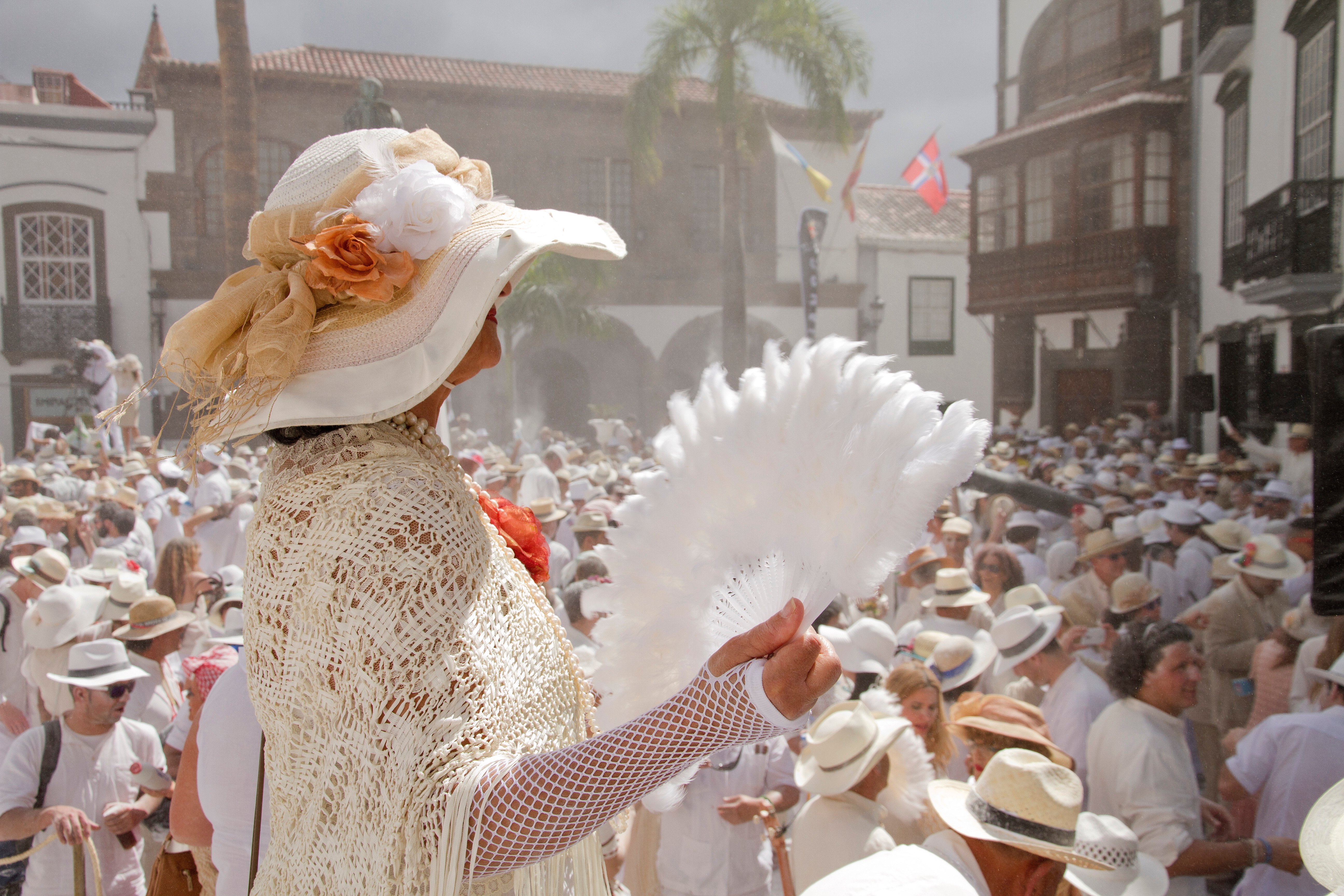 Una mujer madura se abanica en plena Plaza de España de la capital palmera durante la celebración de Los Indianos